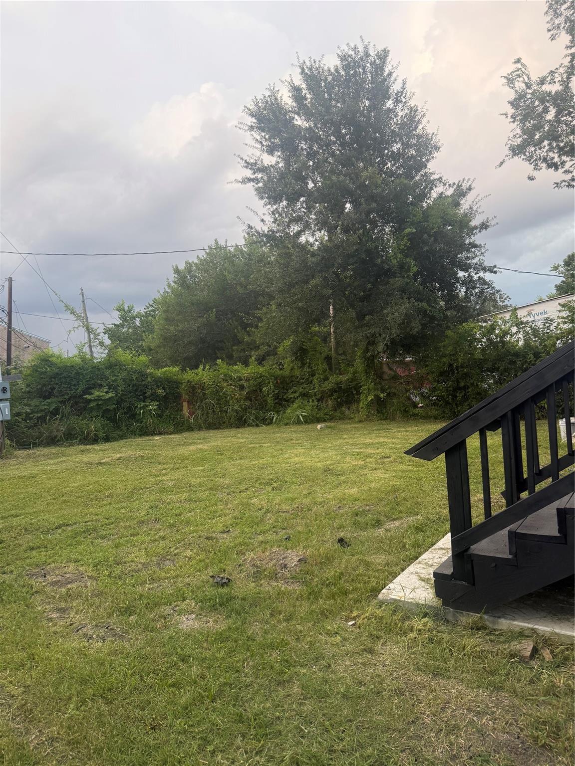 Large grassy backyard with deck steps