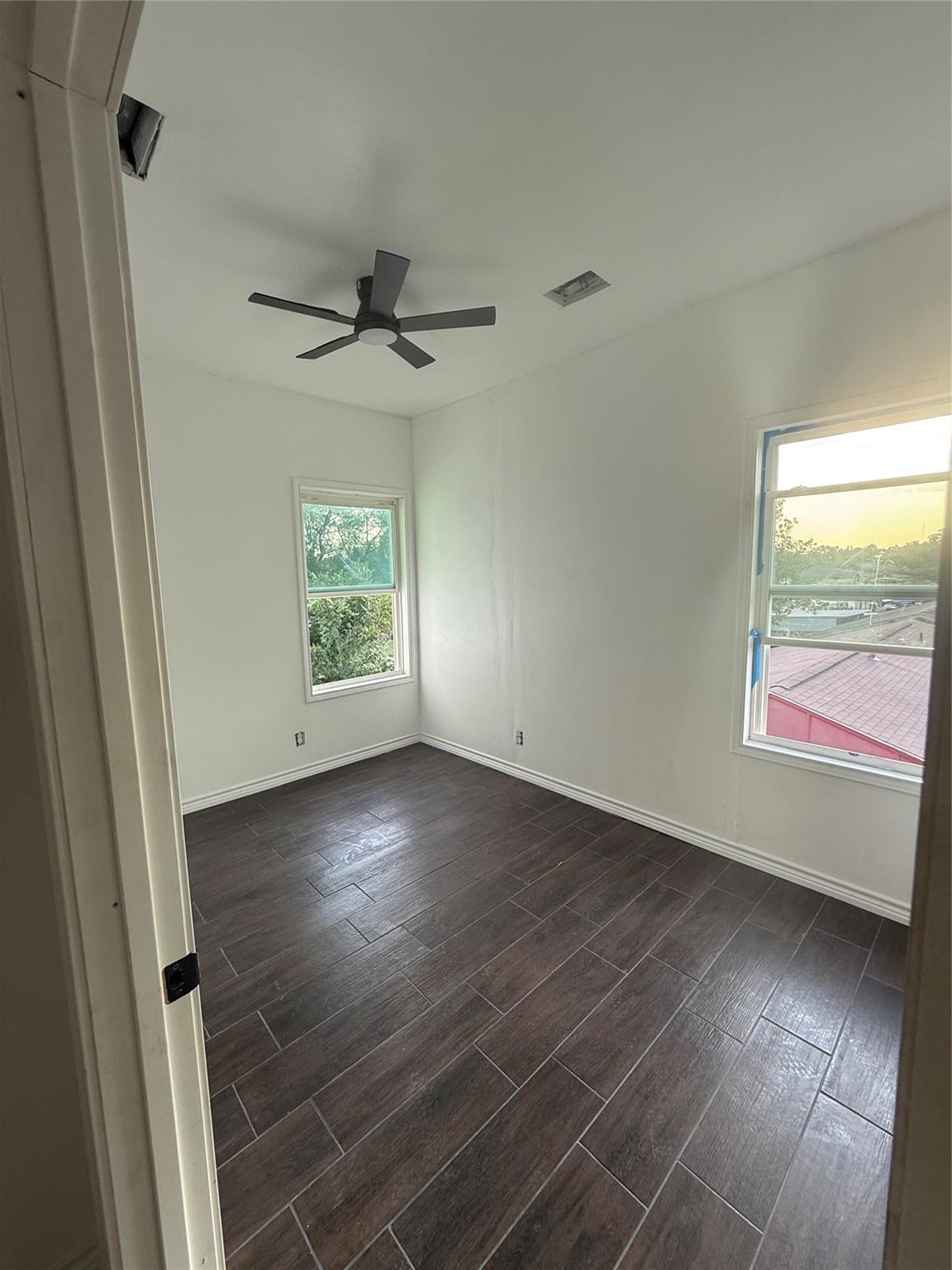Private bedroom with ceiling fan and two windows