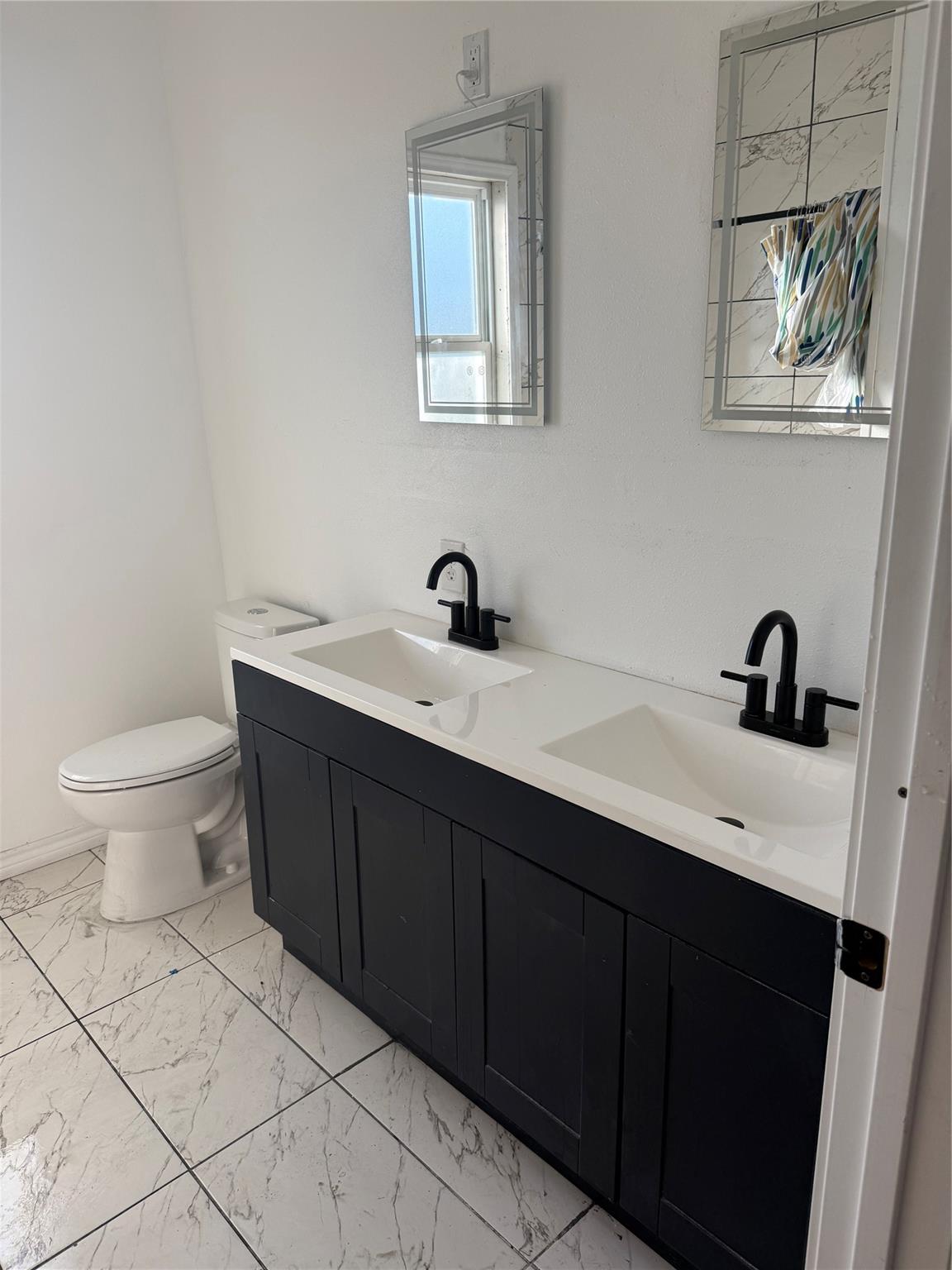 Full bathroom with double vanity and marble-look tile
